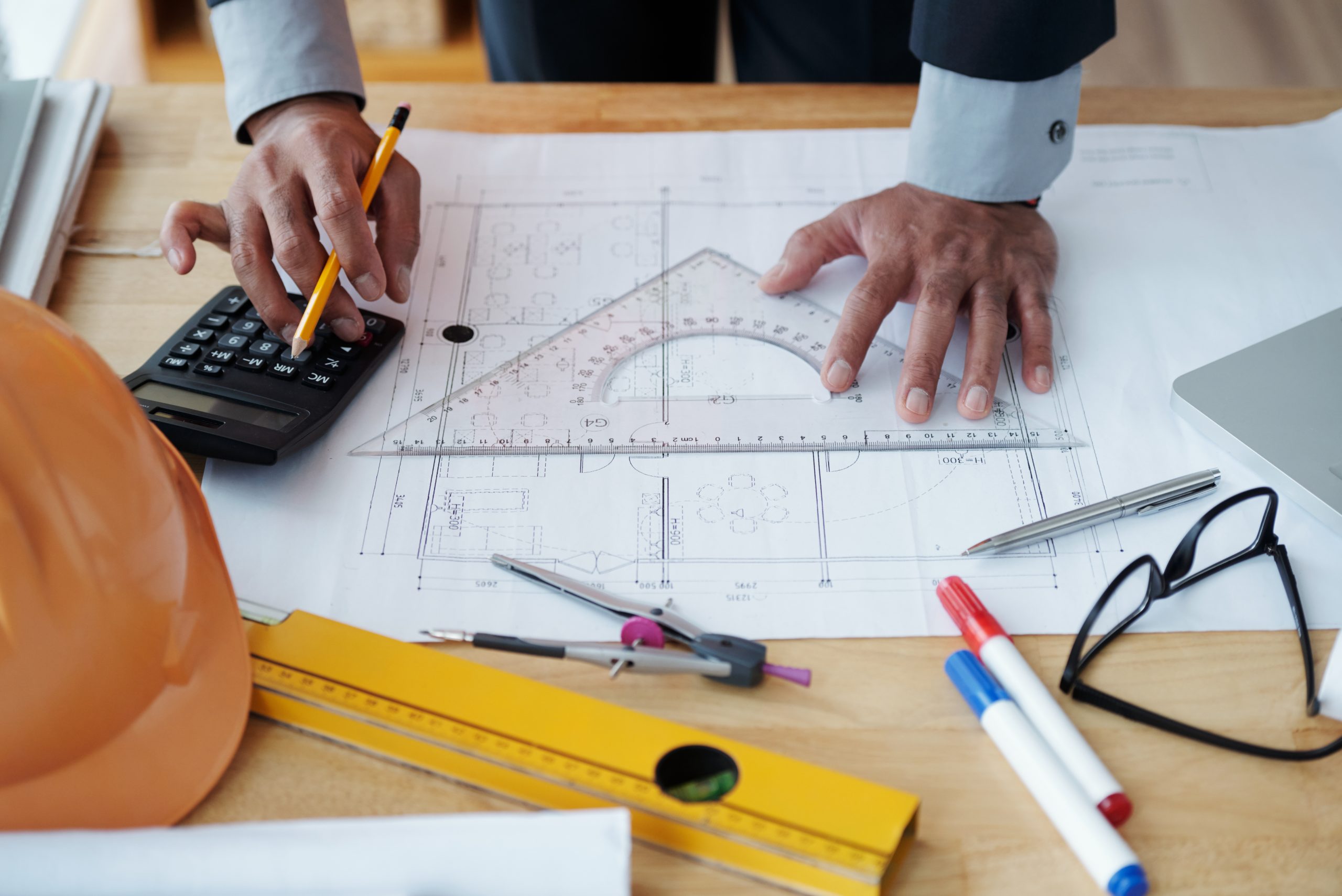 Hands of engineer checking construction plan on his table